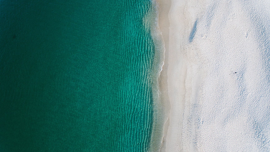 Aerial View of Turquoise Ocean Waves Meeting White Sandy Beach