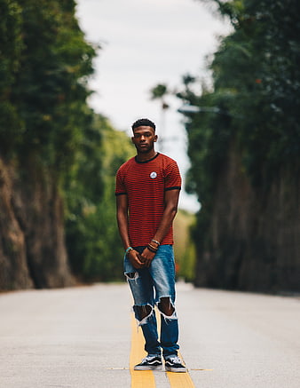 Young Man in Striped Shirt Standing on Road