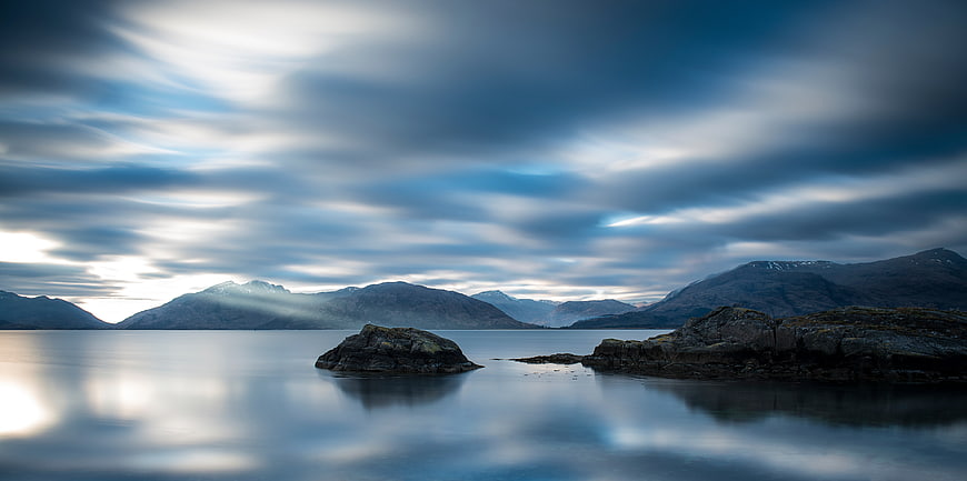 Serene Long Exposure Coastal Landscape with Misty Mountains
