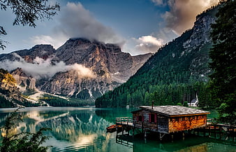 Serene Alpine Lake with Wooden Boathouse and Mountain Reflections