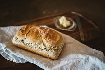 Freshly baked loaf of bread on linen with butter