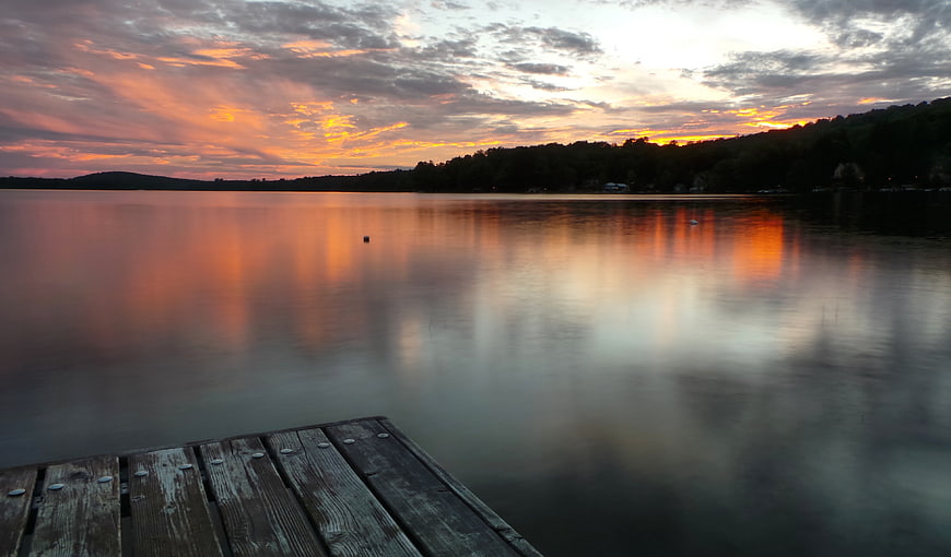 Serene Lake Sunset with Wooden Dock and Reflections