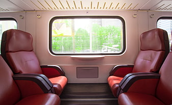 Empty red leather seats in a modern train carriage interior