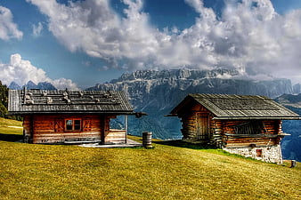 Rustic Alpine Cabins on Grassy Mountain Slope