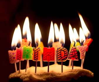 Lit Birthday Candles Spelling Happy Birthday on Cake