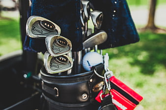 Close-up of golf clubs in a bag with golf ball