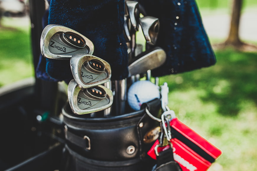Close-up of golf clubs in a bag with golf ball