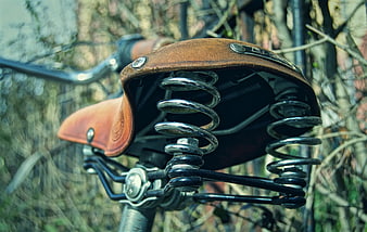 Close-up of vintage leather bicycle saddle with chrome springs