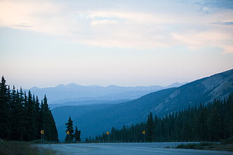 Winding Mountain Road at Dusk with Blue Forest Layers
