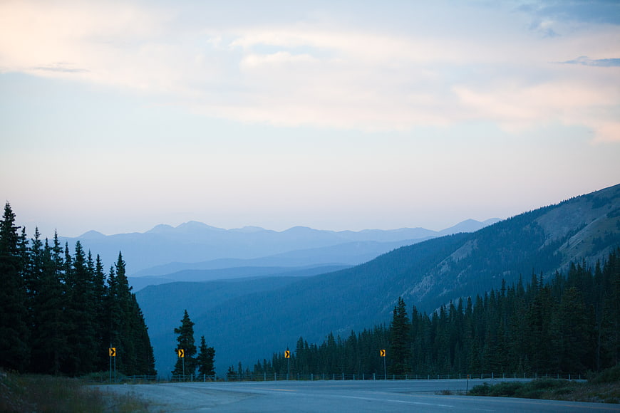 Winding Mountain Road at Dusk with Blue Forest Layers