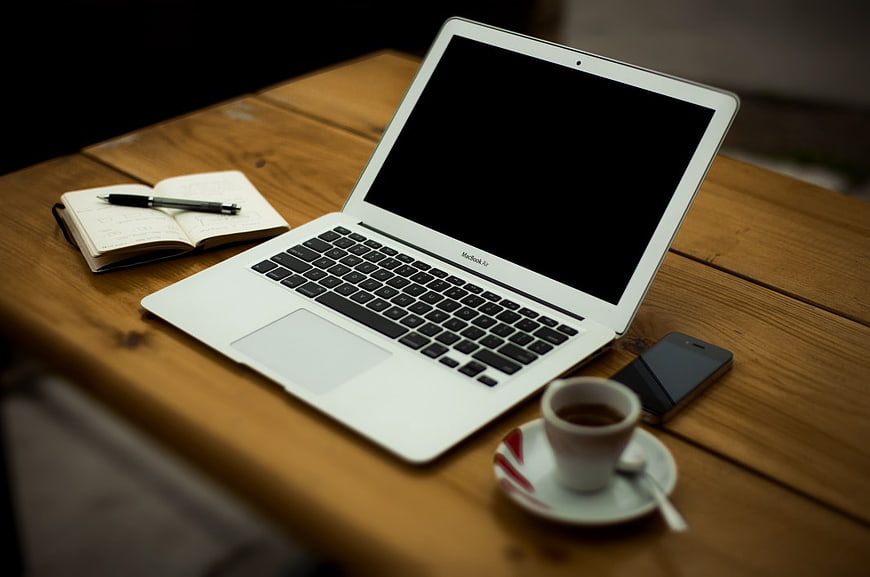 White MacBook Laptop with Coffee and Notebook on Wooden Table