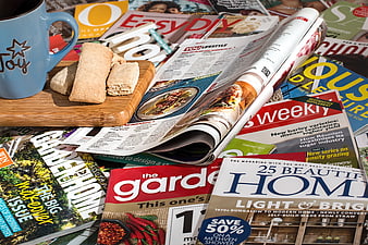 Stack of Lifestyle Magazines with Coffee and Biscuits on Wooden Board