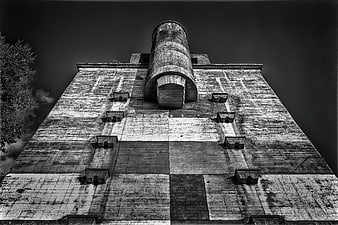 Low angle black and white view of weathered concrete tower