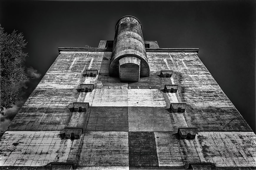Low angle black and white view of weathered concrete tower