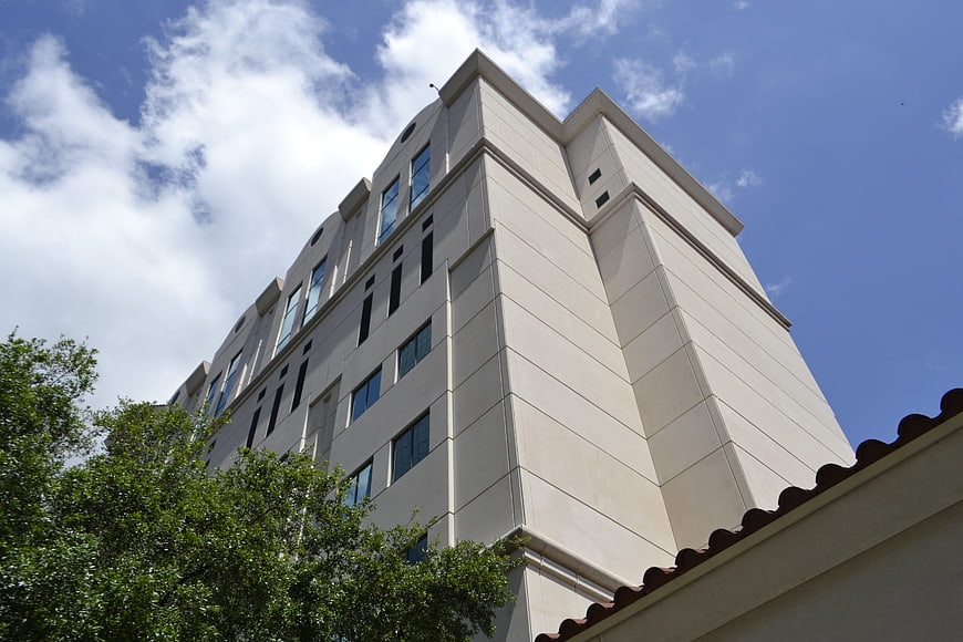 Low angle view of modern beige office building against blue sky