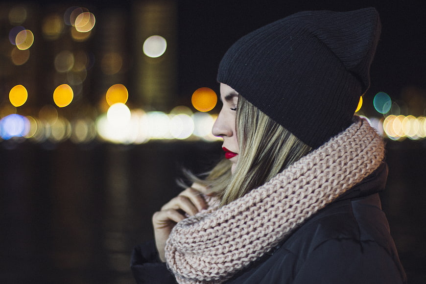 Woman in Beanie and Scarf with City Bokeh Lights