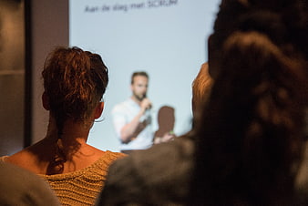 Audience watching a man present at a corporate conference