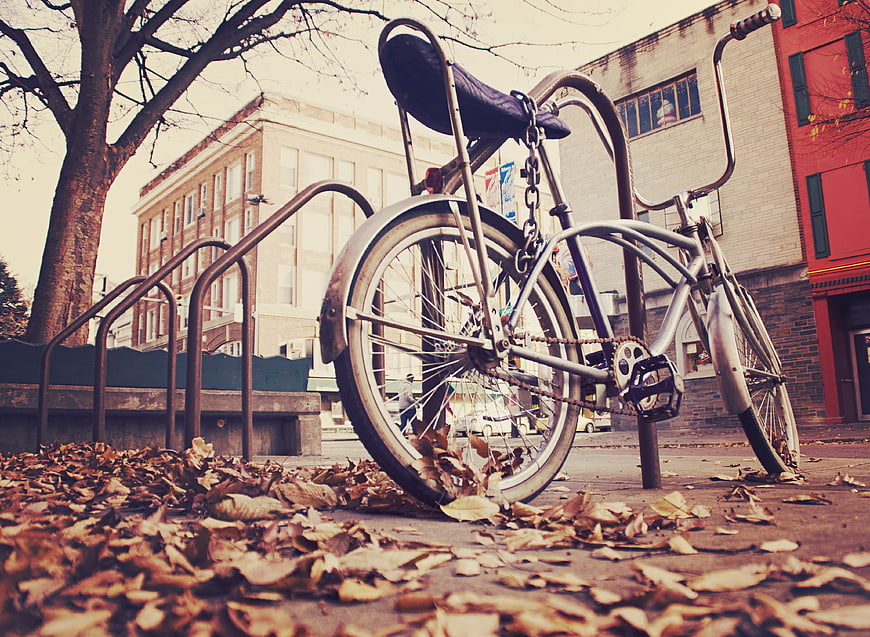 Vintage Bicycle Parked on Sidewalk with Autumn Leaves