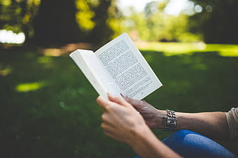 Woman Reading Book Outdoors in Park
