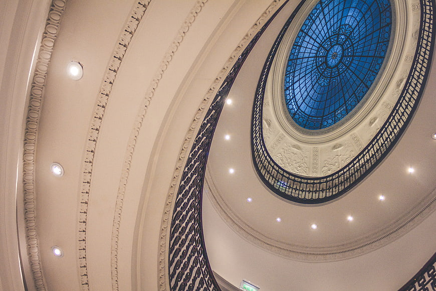 Grand spiral staircase with blue stained glass dome ceiling