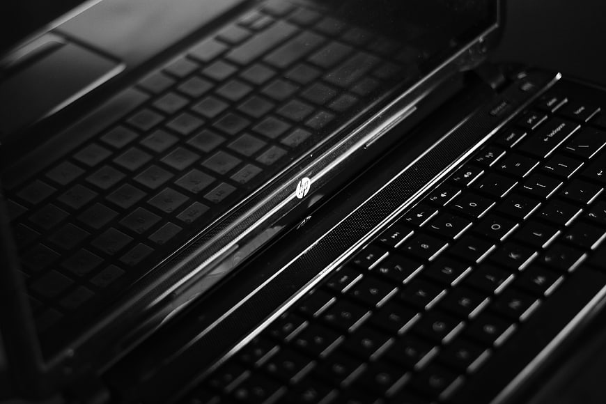 Close-up of black HP laptop keyboard in monochrome