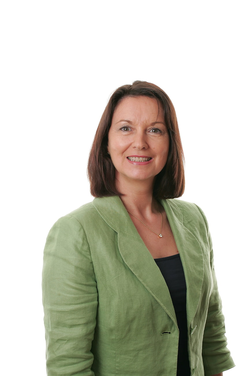 Smiling mature businesswoman in green blazer on white background