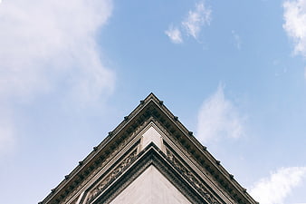 Low angle view of Arc de Triomphe corner against blue sky