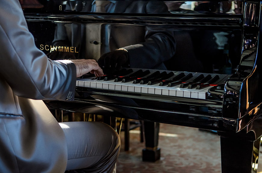 Man in Suit Playing Grand Piano Keys Close Up