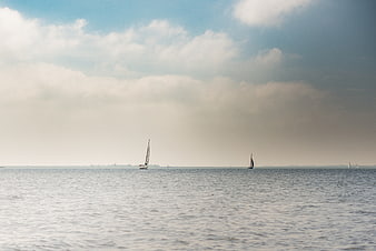Sailboats on Calm Sea Under Cloudy Sky
