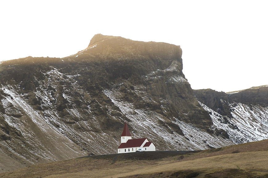 White Church with Red Roof in Snowy Mountain Landscape