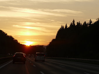 Cars driving on highway during golden sunset