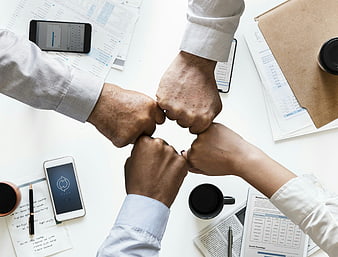 Top view of diverse business team fist bumping over office desk