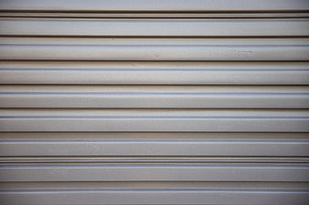 Close-up of beige corrugated metal garage door texture