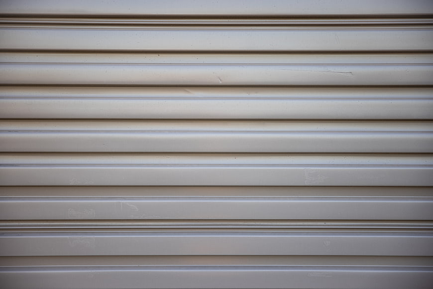 Close-up of beige corrugated metal garage door texture