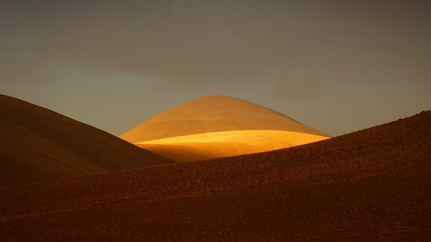 Golden Sunlight Illuminating Desert Dunes And Rolling Hills