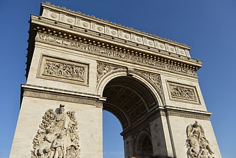 Low angle view of the Arc de Triomphe in Paris against blue sky