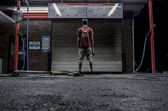 Man Standing Alone at Closed Car Wash at Night