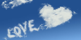 Heart-shaped cloud and LOVE text in blue sky
