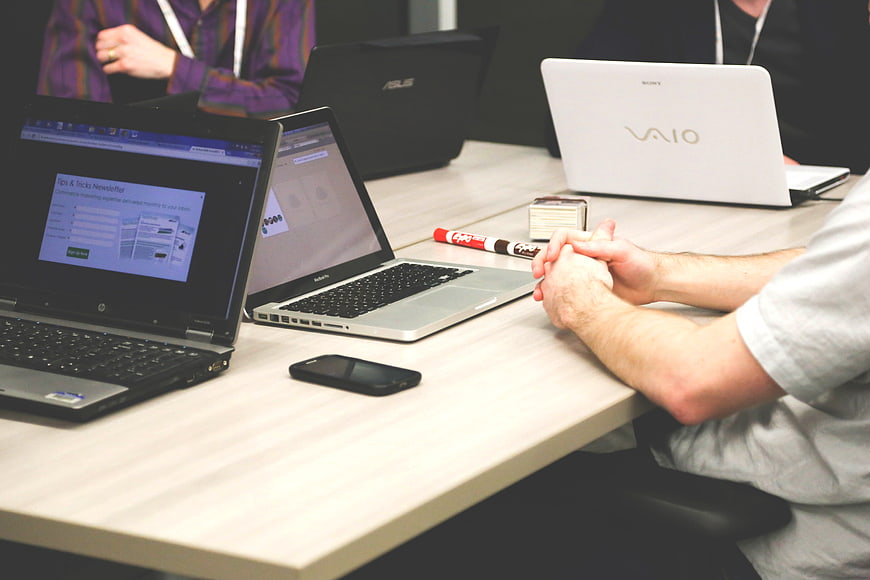 Team meeting with laptops and smartphones on office desk