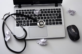 Stethoscope on laptop keyboard with crumpled paper