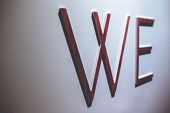 Wooden WE letters on white wall with copyspace