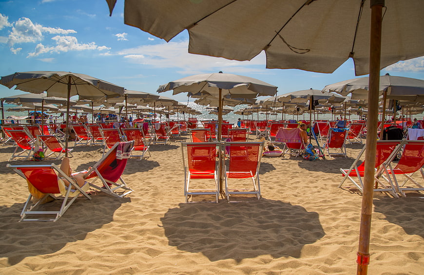 Red Beach Chairs and Umbrellas on Sandy Shore