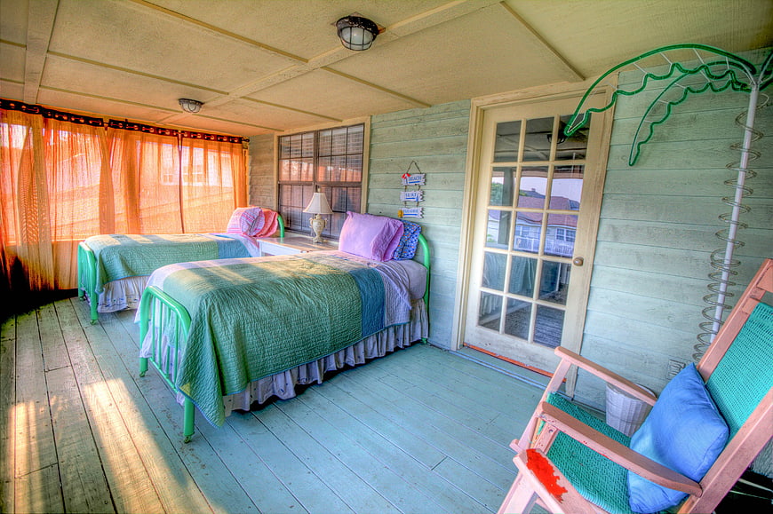 Rustic Porch Bedroom With Green Beds And Vintage Chair