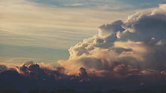 Dramatic sunset clouds with golden light and dark stormy base