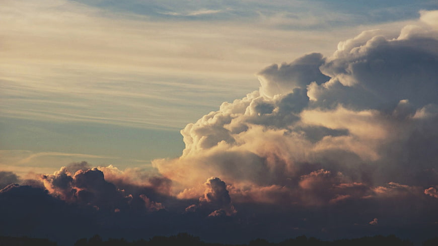 Dramatic sunset clouds with golden light and dark stormy base
