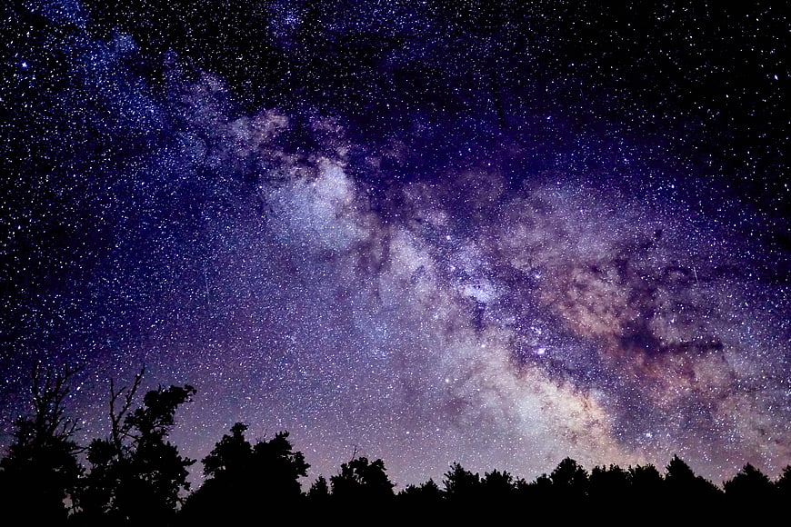 Milky Way Galaxy Rising Over Dark Forest Silhouette at Night