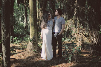 Happy couple smiling and talking in a sunlit forest