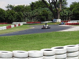 Go-kart racing on outdoor track with tire barriers