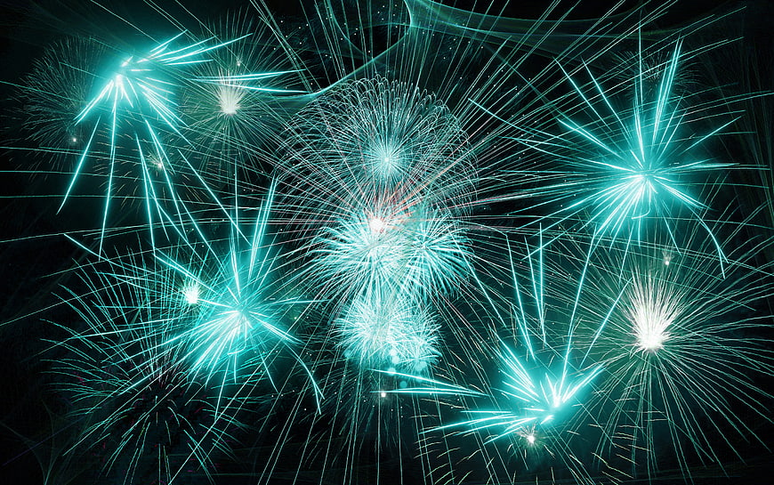 Vibrant Cyan Fireworks Exploding in Night Sky