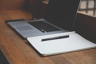 Laptop and Notebook on Wooden Desk